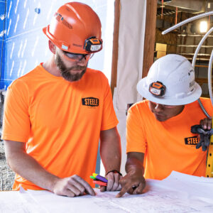 Steele Electric Journeyman Electrician and Apprentice Electrician review electrical plans on Oregon commercial job site.