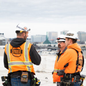 Steele Electric Electricians hold safety briefing on downtown rooftop as part of large commercial electrical service job.